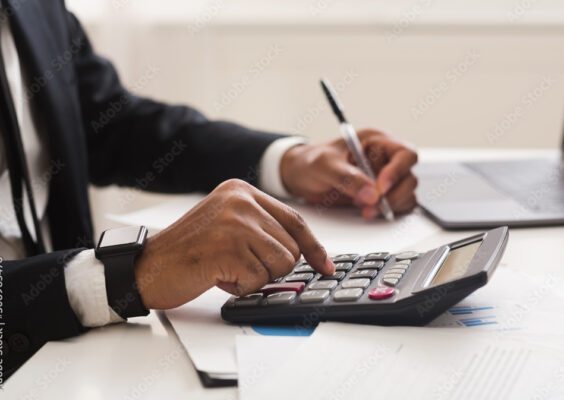 Close up of man checking on incomes, using calculator